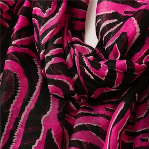 Détail macro d'une écharpe imprimé zèbre fuchsia et noir en tissu doux léger