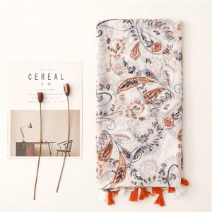 Ivory paisley cotton linen scarf with two-tone tassels and magazine prop arrangement