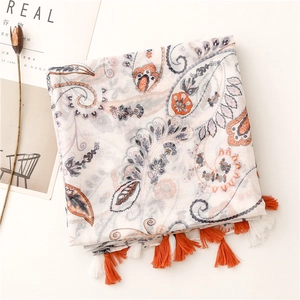 Detail of paisley pattern print and orange fringe tassels on lightweight linen scarf