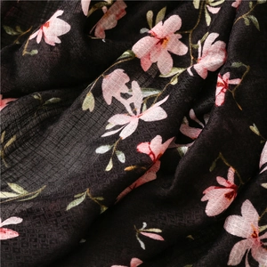 Macro detail of breathable linen-feel fabric with pink floral print on black base