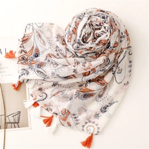 Beige cotton linen scarf with vintage paisley print and orange tassels on a white background