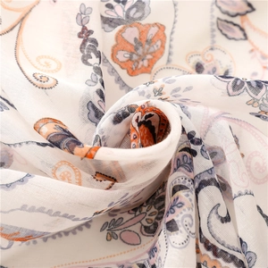 Detailed close-up of light paisley print on soft cream fabric with delicate textures