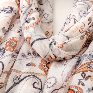 Detail of bohemian paisley pattern on off-white cotton blend scarf with soft texture