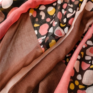 Detailed macro shot of lightweight scarf fabric with colorful polka dots and mosaic patterns