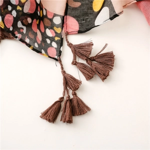 Detail of colorful polka dot cotton scarf featuring brown fringe tassels on the edge
