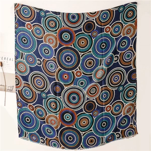 Detail of artistic mandala patterns and raw fringe edges on a silk-like ethnic scarf
