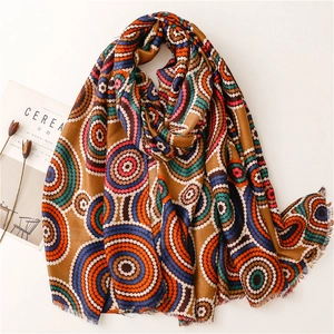 Bohemian style scarf with colorful mandala patterns and fringed edges on a beige surface