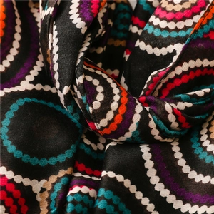 Detail of colorful concentric circle patterns on soft black cotton-linen blend scarf