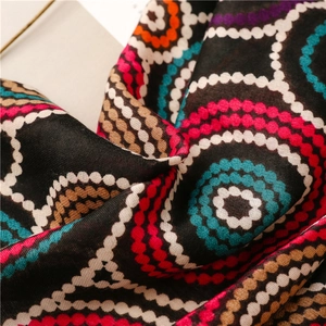 Close-up of lightweight black scarf with colorful kaleidoscope polka dot patterns