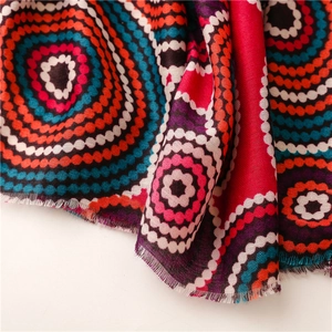 Detailed close-up of kaleidoscopic colorful rings and fringe edges on a soft cotton scarf