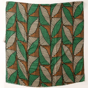 Detailed top view of a soft cotton-linen scarf with abstract green leaf texture and tag