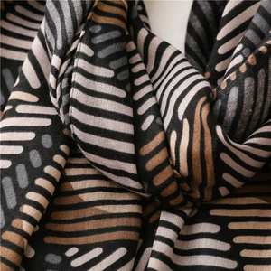 Macro view of geometric striped cotton scarf showing fine fabric texture and color block detail
