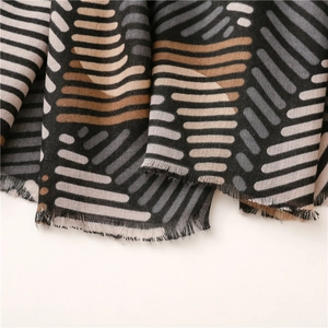Close-up of geometric striped scarf with soft cotton-linen texture and frayed edges