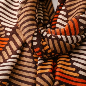 Detailed view of striped woven scarf with soft texture in brown, tan, and warm orange hues