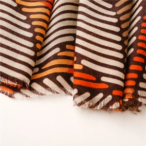 Detailed texture of brown and orange wave pattern scarf with soft fringe edges