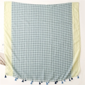 Detailed flat lay of lightweight scarf showing blue floral print and fringe tassels