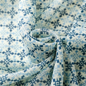 Detailed close-up of blue and white geometric snowflake pattern on lightweight beach shawl