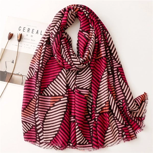 Detail of soft multi-color geometric striped scarf with delicate frayed edge finish
