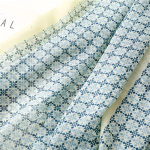 Detail of bohemian geometric star patterns on a lightweight blue summer scarf fabric
