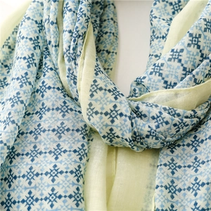 Detail shot of light yellow cotton linen scarf showing blue geometric cross patterns