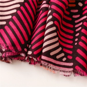 Close-up of soft striped cotton-linen scarf with geometric patterns and fringe detail