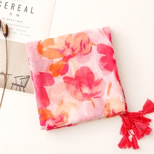 Détail de l'écharpe à fleurs roses avec de longs glands sur un fond blanc de style de vie