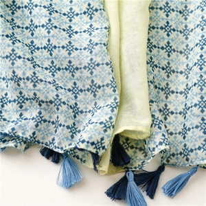 Macro detail of geometric diamond print scarf with layered blue tassel fringe trim