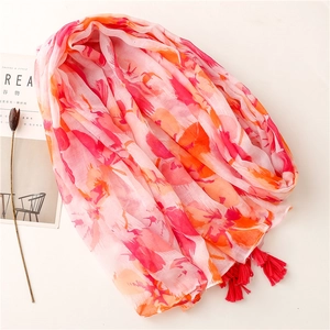 Écharpe en coton et lin à fleurs rose et orange avec pompons rouges sur fond clair