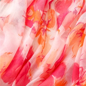 Détail macro d'une écharpe légère avec imprimé floral aux tons rose et orange doux