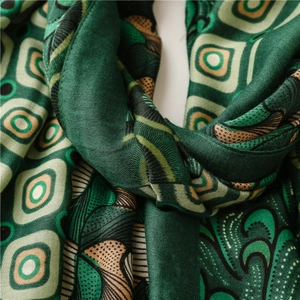 Macro shot of emerald green long scarf showing soft satin texture and ring pattern
