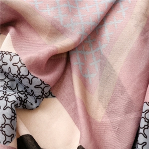 Detailed close-up of pink and beige geometric plaid scarf with delicate fringed edges