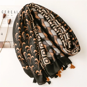 Detail of multi-color paisley pattern scarf with elegant tassels and silky texture