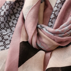 Detail of pink and grey geometric pattern scarf showing fine twill fabric and soft texture