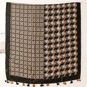 Detail of color-block paisley scarf with geometric patterns and fringe tassels
