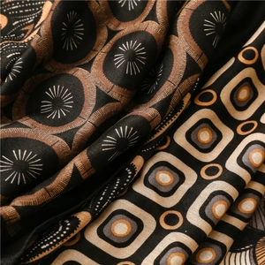 Detail of soft fabric scarf showing intricate geometric patterns and smooth texture