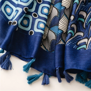 Detail of blue paisley print scarf showing intricate patterns and soft tassel fringe edges