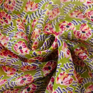 Detail of floral printed linen texture fabric with pastel green base and artistic blossoms
