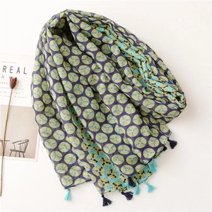 Bohemian cotton linen scarf with green geometric circles and tassels on a white surface