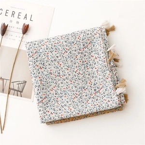 Detail of floral linen-feel scarf with red berries pattern and soft fringe tassels