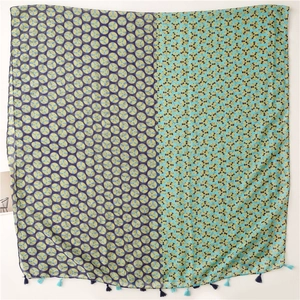 Close-up of geometric polka dot scarf fabric with soft blue and purple fringed tassels