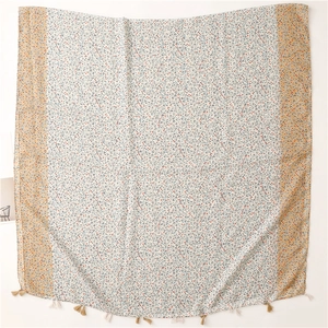 Detail view of floral cotton scarf with tassel fringe and intricate vine pattern print