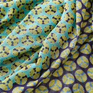 Macro detail of breathable fabric scarf with green polka dots and light fringe texture