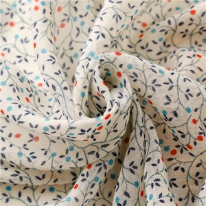 Detail of floral printed scarf showing soft linen-feel fabric and delicate tassels
