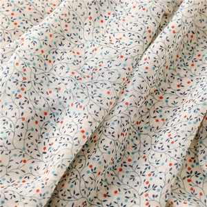 Detailed macro view of lightweight cotton scarf fabric with orange floral patterns