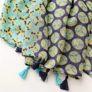Detail of soft fabric scarf featuring colorful geometric patterns and decorative tassels