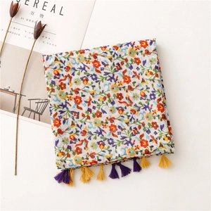 Detailed view of floral pattern scarf with colorful fringes and soft cotton-linen texture