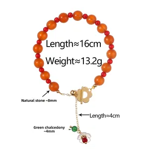 Detail of beaded bracelet with 8mm orange stones, gold OT clasp and flower pendant