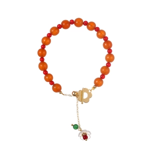 Ethnic beaded bracelet with red chalcedony stones and a golden floral OT clasp