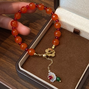 Handmade stone bracelet with orange carnelian beads, flower toggle clasp, and petal charm