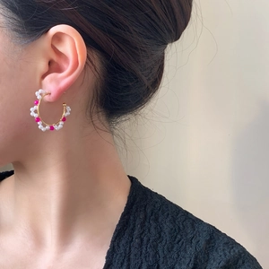 Élégantes créoles en C dorées avec perles blanches et perles magenta sur mannequin